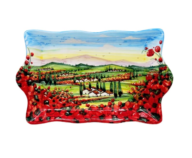May include: Rectangular ceramic serving platter with a hand-painted Italian landscape scene. The design features rolling green hills, white buildings, and vibrant red poppies. The rim is scalloped and decorated with more poppies.
