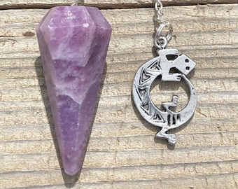 Pode incluir: Um pêndulo de cristal de ametista roxo com uma corrente de prata e um pingente de prata em forma de lagarto. O pingente é preso à corrente com um anel de prata.