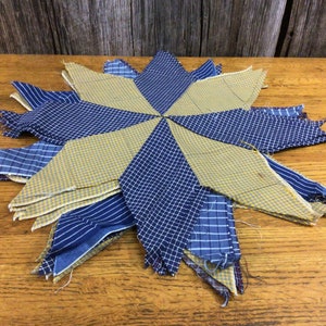 May include: A blue and yellow patchwork quilt in the shape of a star. The quilt is made of different fabrics with a checkered pattern.