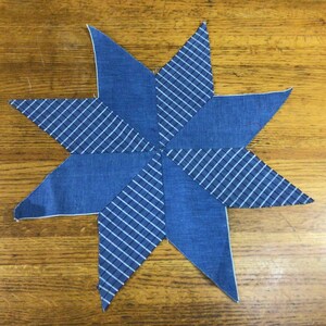 May include: A blue and white star-shaped fabric patchwork with a checkered pattern.