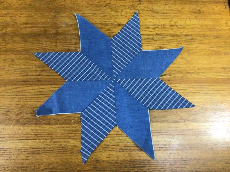 May include: A blue and white star-shaped fabric patchwork with a checkered pattern.