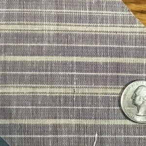 May include: Close-up of a purple and white striped fabric with a woven texture. A US quarter is placed on the fabric for scale.