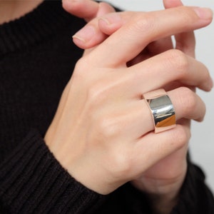 Op de afbeelding: Een brede zilveren ring met een gladde, gepolijste afwerking.