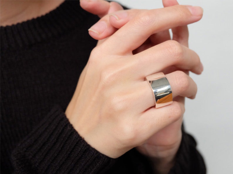 Op de afbeelding: Een brede zilveren ring met een gladde, gepolijste afwerking.