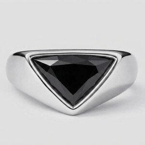 May include: A silver ring featuring a large, triangular black gemstone. The ring has a polished finish and a contemporary design. The black stone is faceted, reflecting light. A striking piece of jewellery.