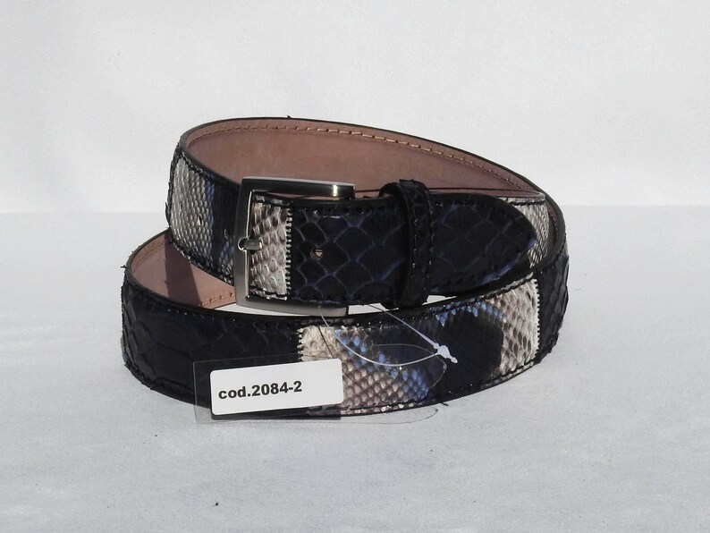 May include: A black leather belt with a snakeskin pattern and a silver buckle. The belt has a tag that says "cod.2084-2".