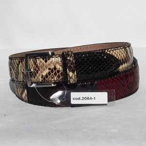May include: A brown, black and red snakeskin belt with a silver buckle. The belt has a tag that reads "cod.2084-1".