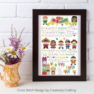 May include: A framed cross-stitch artwork with a dark brown frame. The artwork features colorful text and cartoon figures, including the phrase "It's a small world." The design includes various characters and the text "There is just one moon and one golden sun."