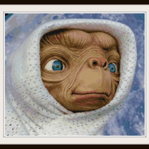 May include: A close-up of a brown alien with large blue eyes wearing a white hooded garment. The alien has a serious expression on its face.