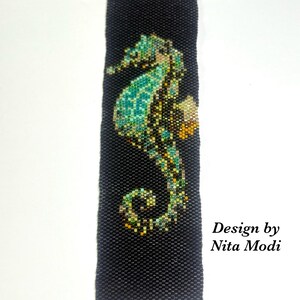 May include: Black beaded bracelet featuring a seahorse design in shades of teal, green, and gold. The bracelet has a gold-tone clasp and a decorative charm. Text on the image reads "Beadazzledgems" and "Design by Nita Modi."