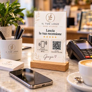 Può includere: Un cartello in acrilico trasparente su base in legno con il testo Lascia la tua recensione, cinque stelle, un'icona NFC e un codice QR. Il cartello riporta la scritta Il Tuo Logo Nome Attività e Grazie con un cuore per le recensioni dei clienti.