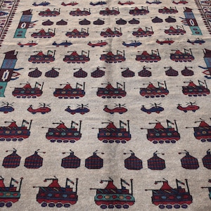 May include: A beige rug with a repeating pattern of stylized tanks and helicopters. The rug has a brown, red, and blue border.