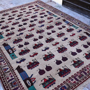 May include: A beige rug with a repeating pattern of stylized vehicles in shades of red, blue, and green. The rug has a border of intricate floral designs in shades of burgundy and white.