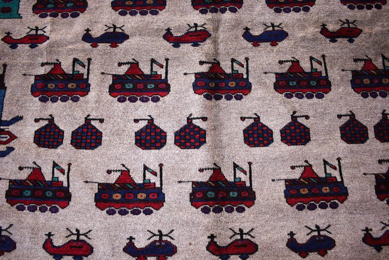 May include: A beige rug with a repeating pattern of stylized helicopters and tanks. The helicopters are blue and the tanks are red, white, and blue.
