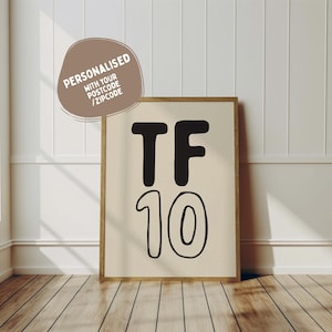 May include: A framed print with a beige background and black text that reads "TF 10".
