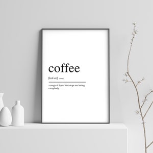 Op de afbeelding: Zwart-witte printbare wandkunst met een definitie van het woord "koffie". De definitie luidt: "[kof-ee] (zelfstandig naamwoord) een magische vloeistof die me stopt met haten iedereen."