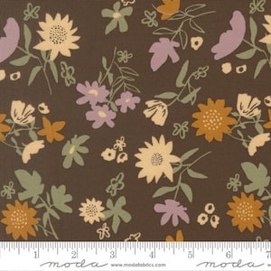 May include: A dark brown fabric featuring a repeating pattern of stylized flowers and leaves in shades of cream, muted yellow, sage green, and dusty purple. A white measuring tape is visible at the bottom, showing a scale in inches.