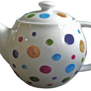 May include: White ceramic teapot with a lid and handle, decorated with colourful polka dots in shades of blue, green, orange, purple, and pink. The teapot has a curved spout and a rounded body.