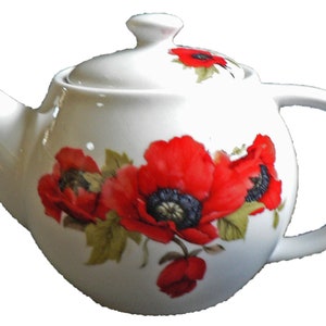 May include: White ceramic teapot with a lid, decorated with bright red poppy flower designs. The teapot has a curved handle, a spout, and a lid with a small knob. The poppy flowers have black centres and green leaves.