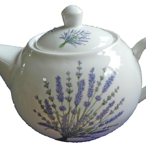 May include: White ceramic teapot with a lid, featuring a lavender floral design. The teapot has a round body and a curved handle.