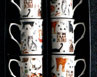 May include: Set of six white ceramic mugs with black handles. Each mug features a different colorful illustration of cats with various patterns and designs.