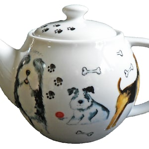 May include: White ceramic teapot with a lid, spout, and handle. The teapot is decorated with illustrations of dogs, paw prints, and bones. The dogs are in various poses and colours, with a red ball.