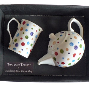 May include: A two-cup teapot and matching bone china mug with a colourful polka dot design. The set is packaged in a black gift box.
