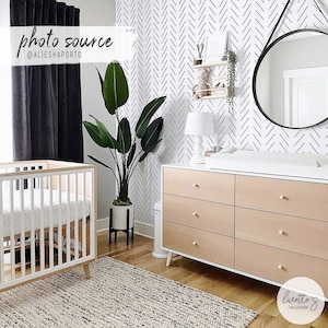 Black and white herringbone wallpaper in modern glam style nursery
