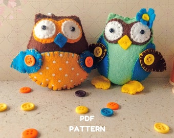May include: PDF pattern for two felt owl toys. One owl is brown and orange with white polka dots, the other is green and blue with a yellow flower on its head. Both owls have yellow feet and brown eyes.
