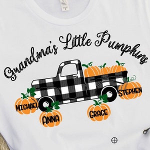May include: White t-shirt with black text that reads "Grandma's Little Pumpkins". A black and white checkered pickup truck is carrying pumpkins with the names Michael, Anna, Grace, and Stephen.