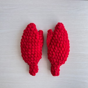 May include: A pair of red knitted mittens with a textured, puffy design.