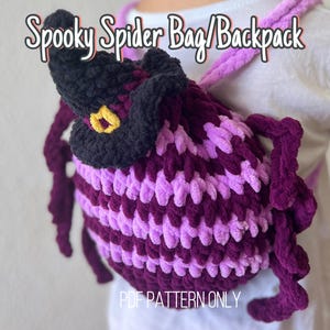 May include: A purple and pink crocheted spider bag or backpack with a black witch hat on top. The text "Spooky Spider Bag/Backpack" is above the bag and the text "PDF PATTERN ONLY" is below the bag.