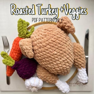 May include: A crocheted turkey and vegetables on a white plate. The turkey is brown and white, and the vegetables are green, orange, and purple. The text "Roasted Turkey + Veggies PDF PATTERN ONLY" is above the plate.