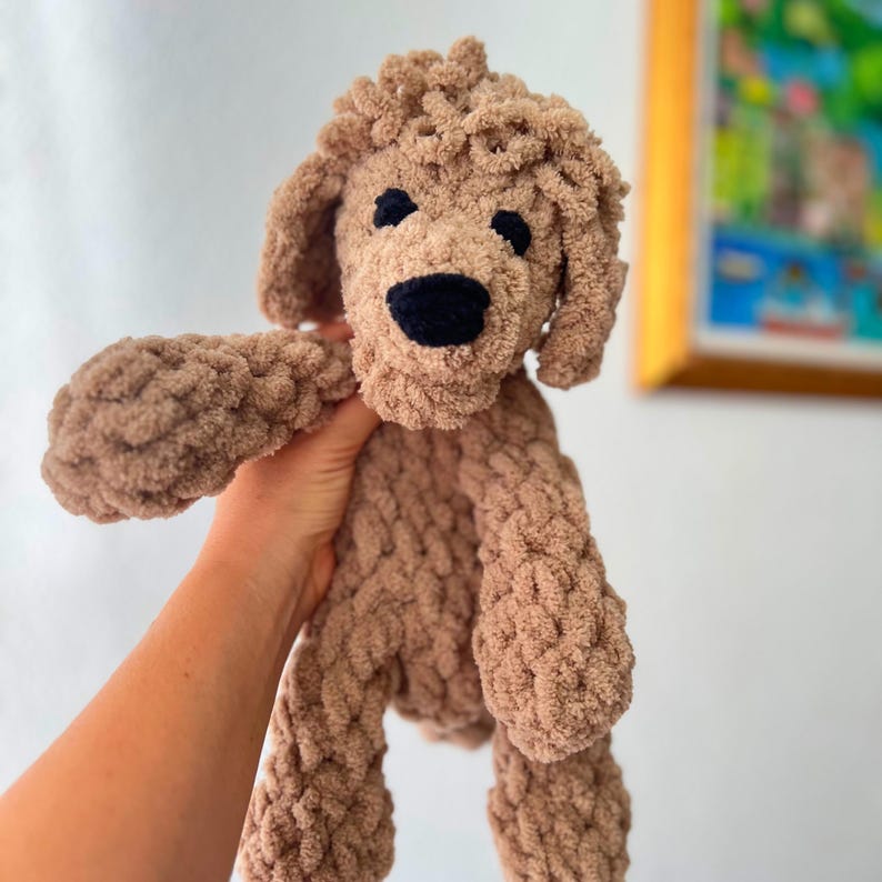 Pode incluir: Um brinquedo de pel&uacute;cia feito &agrave; m&atilde;o em forma de poodle na cor marrom claro. O c&atilde;o tem um nariz e olhos pretos, e seu pelo &eacute; texturizado. O brinquedo &eacute; macio e fofinho, perfeito para crian&ccedil;as ou como objeto decorativo.