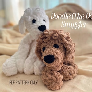 May include: Two handmade crochet dog plushies, one white and one brown, are shown. The white dog is seated behind the brown dog. Both have black eyes and noses. The text "Doodle (The Dog) Snuggler" and "PDF PATTERN ONLY" are visible.