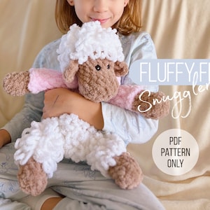 Puede incluir: Un peluche de oveja hecho a mano, esponjoso, en blanco, marrón y rosa. La oveja tiene cabeza blanca, cara y pezuñas marrones, y brazos rosas. El texto "FLUFFY FLO Snuggler" y "PDF PATTERN ONLY" son visibles.
