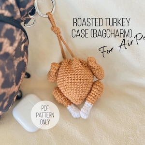 May include: A crocheted roasted turkey case (bag charm) for Air Pods. The turkey is brown with white accents on the legs. The text "Roasted Turkey Case (Bagcharm) For Air Pods" is visible. A white Air Pods case is also visible.