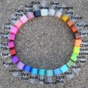 Pu&ograve; includere: Una cartella colori di glitter in piccoli vasetti di vetro. I colori sono disposti in cerchio, a partire dal nero, dal bianco, dall'argento, dallo champagne, dall'oro, dal rame, dalla zucca, dall'espresso, dall'arancione neon, dal giallo neon, dal verde neon, dal verde, dalla menta, dall'azzurro, dal blu pavone, dal blu verde, dall'acquamarina, dal blu scuro, dalla lavanda, dal viola, dal rosso, dal rosa scuro, dal rosa petalo, dal rosa acceso, dal corallo, dal rosa chiaro e dall'oro chiaro.