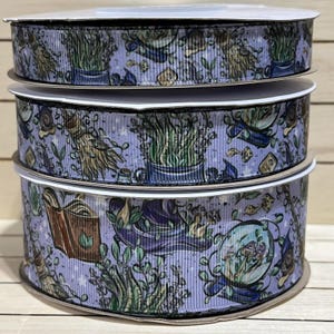 May include: Three spools of purple ribbon with a white background and a repeating pattern of green herbs, a witch's hat, and a book.