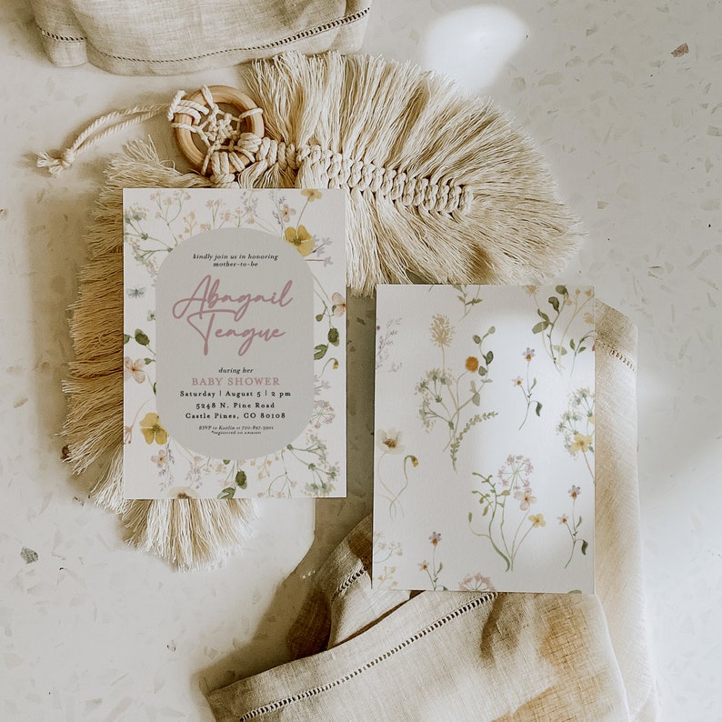 May include: A floral baby shower invitation with a light grey background and a pink oval with the text "Abagail Tengue" in cursive. The invitation includes the date, time, and location of the shower.