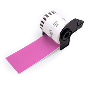 May include: A roll of pink labels is dispensed from a black label dispenser. The label roll is white with black stripes and text that reads "62mm 2-4/9" 205". The labels are a vibrant pink color.
