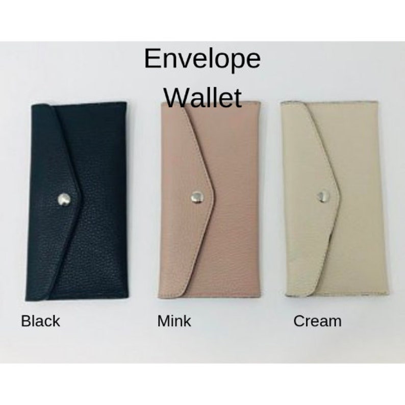 以下が含まれることがあります： 黒、ミンク、クリームの3つの封筒財布。財布は革製で、フラップクロージャーとシルバーボタンが付いています。