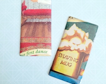 May include: Two vintage-style metal bookmarks. One bookmark features a red, white, and gold design with the text "our first dance". The other bookmark features a green, blue, and yellow design with the text "SHAVING MUG".