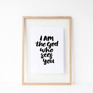 May include: A framed print with the text "I am the God who sees you" in black script on a white background.