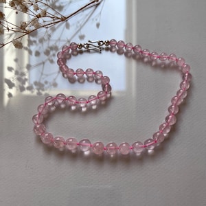 Puede incluir: Un collar de cuentas de cuarzo rosa con cierre de plata.