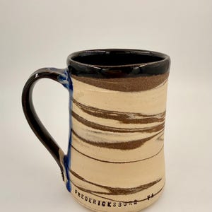 May include: A set of three ceramic mugs with a speckled, matte finish. The mugs are in shades of cream, light gray, and dark gray. Each mug has a simple, minimalist design, perfect for coffee or tea.