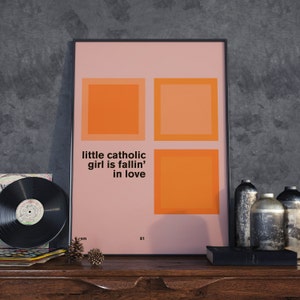 Może przedstawiać: Różowy plakat w czarnej ramie z czterema pomarańczowymi kwadratami. Tekst "little catholic girl is fallin' in love" jest nadrukowany na plakacie czarnym kolorem.