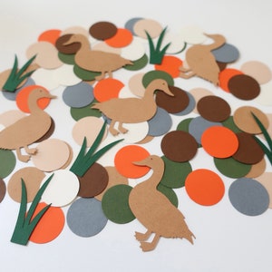 May include: A collection of paper cutouts featuring brown ducks, green grass, and colorful circles in shades of brown, orange, white, and gray.