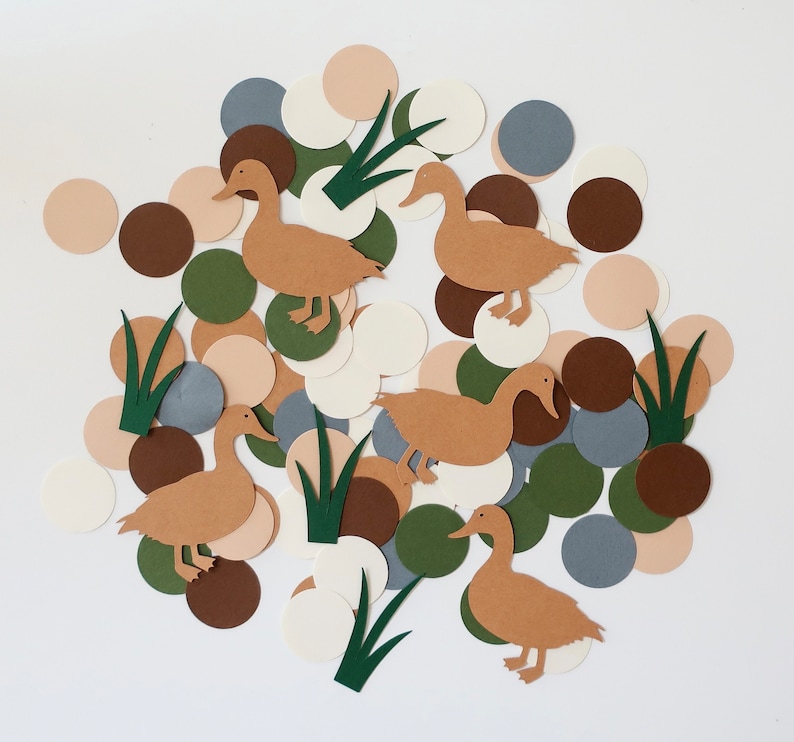 May include: A set of paper cutouts featuring ducks, leaves, and circles in various shades of brown, green, and white. The cutouts are perfect for crafting and decorating.