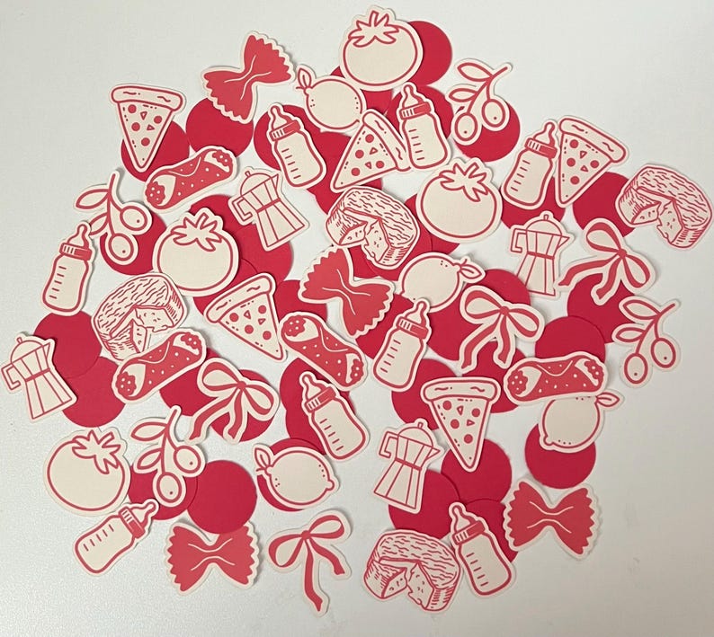 Pu&ograve; includere: Una collezione di forme di carta fustellate rosse e bianche, tra cui spicchi di pizza, pomodori, fiocchi di pasta, biberon, olive, limoni, caffettiere e spicchi di formaggio. Le forme sono sparse su una superficie bianca.